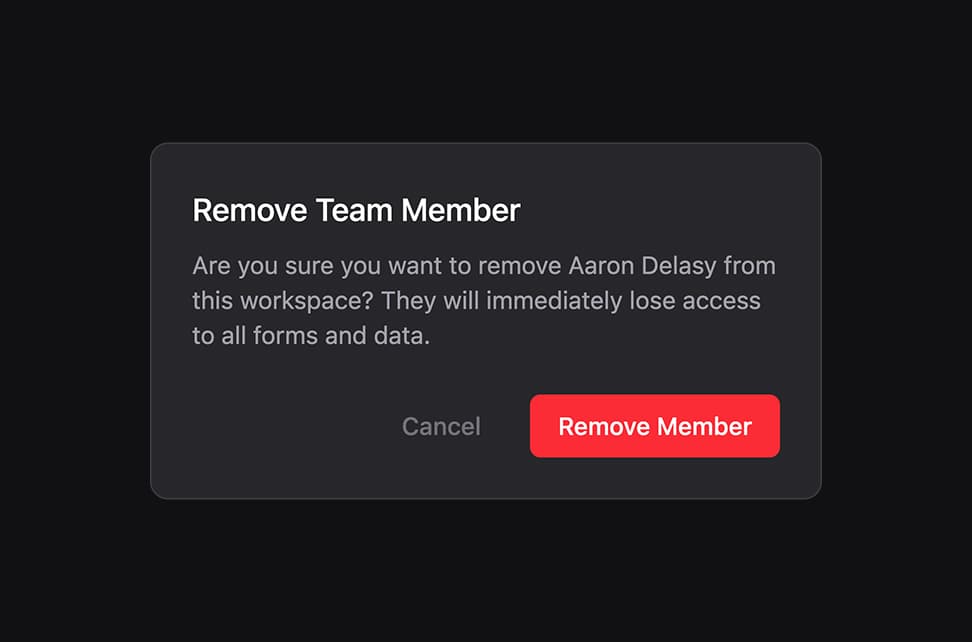 Remove Team Member confirmation modal on dark background with warning text asking Are you sure you want to remove Aaron Delasy from this workspace? They will immediately lose access to all forms and data. Cancel button on left and red Remove Member button on right.